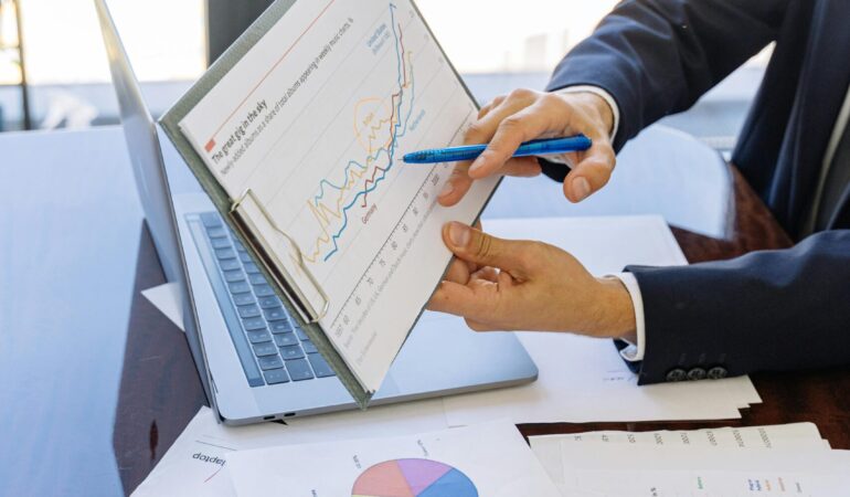 Free Business professionals discussing financial graphs and charts in an office setting. Stock Photo