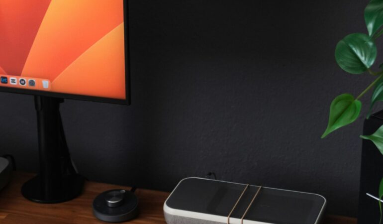 a desk with a laptop, keyboard, mouse and a monitor